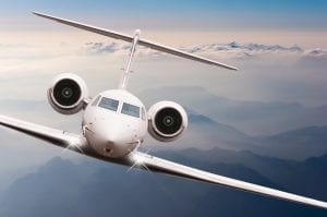 Airplane fly over clouds and Alps mountain on sunset. Front view of a big passenger or cargo aircraft, business jet, airline. Transportation and travel concept.
